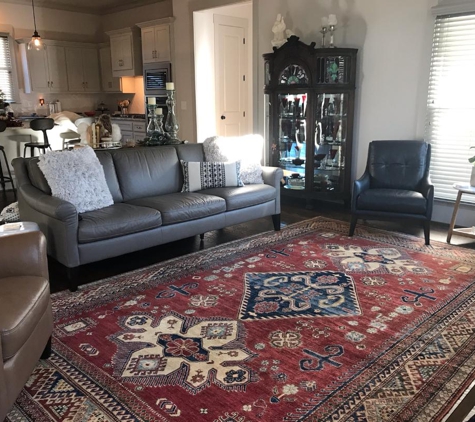Nilipour Oriental Rugs - Birmingham, AL. Kazak Rug radiates life in this living room through bold colors of red and indigo along with  stylized design of multiple medallions!
