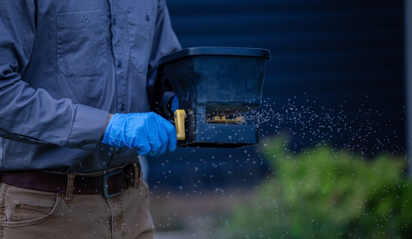 Stonewall Pest Control - Inman, SC. Spreading water activated granules in a band around the home helping create a protective barrier.