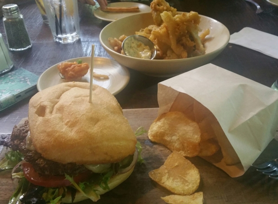 Iron Horse Tavern - Sacramento, CA. Tavern burger with house chips and fried onions and pickles in the backround. Very tasty and satisfying