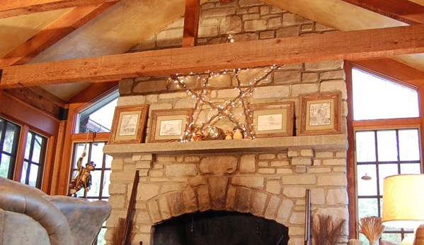 French Masonry - Imperial, MO. Indoor white stone fireplace with raw timber ceiling beams. Cozy cabin feel.