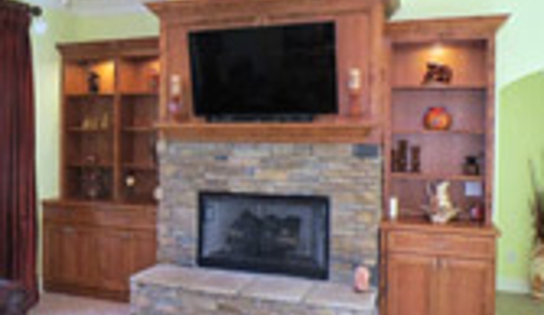 Borders Woodworks - Jacksonville, FL. Custom built fireplace mantel and paneling with adjacent display shelving and cabinets