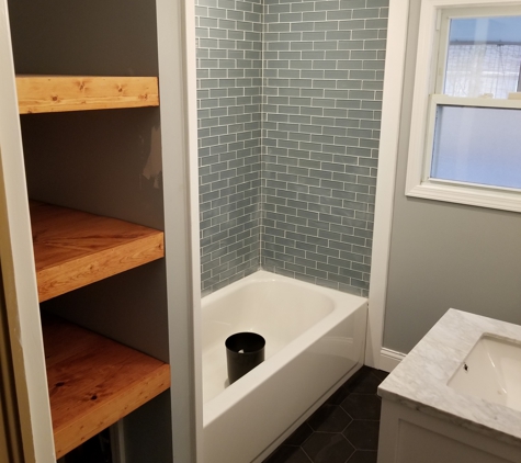 Absolute Interiors and Design, LLC - Cleveland, OH. Subway tile tub surround with custom built oak block shelves