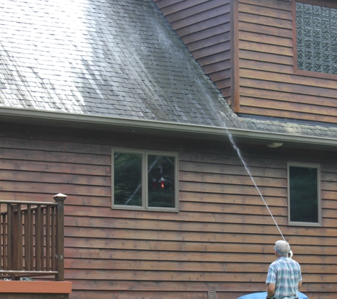 Roof Cleaning and More - Port Huron, MI. He's rinsing off his product after it soaked for awhile.