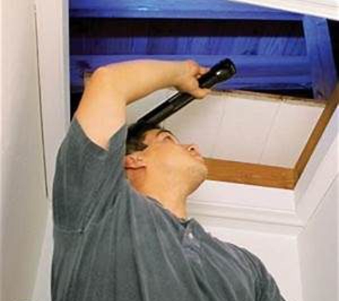 A Accredited Mold Inspection Service, Inc.. Stock image of an inspector looking in an attic.