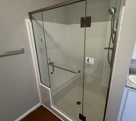Norbert's Glass & Mirror Co. - Grand Rapids, MI. A Custom Frameless Shower Door and Panels with a Support Header and Towel Bar Pull Combo with Showerguard Glass and Brushed Nickel Hardware.